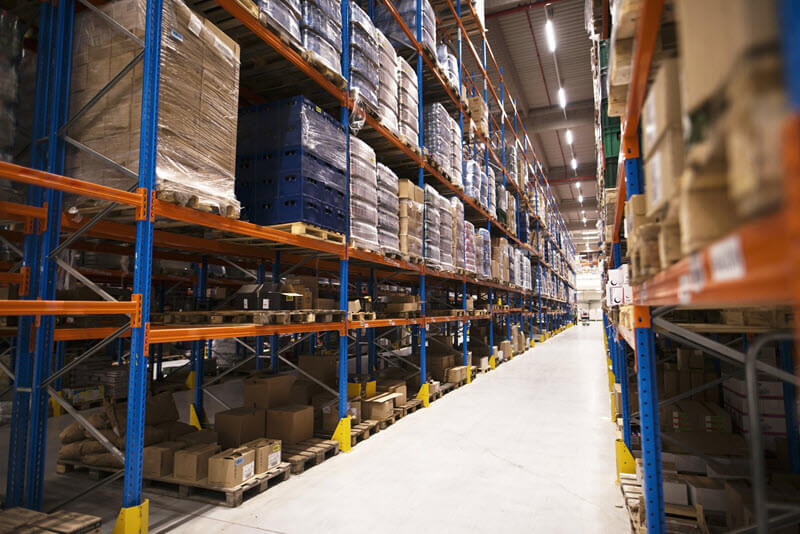 distribution warehouse with shelves stacked with palettes goods